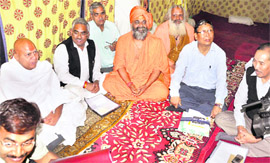 Uttarakhand Tourism Minister Madan Kaushik (in black jacket) and Chief Secretary NS Napalchiyal meet saints of Akhada Parishad in Haridwar on Saturday.