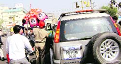 A gunman, accompanying the family of a VIP, purchases toys for the sahibs children, at a busy chowk in Ludhiana. Photo Mahesh Sharma