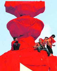 Protesters and supporters of ousted Thai PM Thaksin Shinawatra use red cloth to cover the democracy monument during a protest in Bangkok