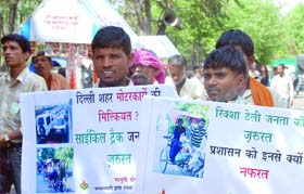 Rickshaw pullers hold placards during the protest rally near Rajghat in New Delhi
