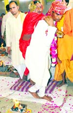 A disabled couple takes round of fire at a mass marriage in Haridwar on Monday. Tribune photo: Rameshwar Gaur