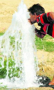 This boy quenches his thirst from a leaking water pipe in a Gurgaon park on a hot day.