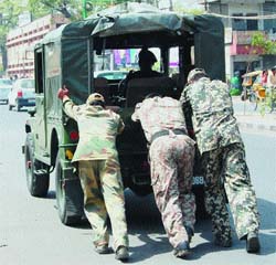 Army jawans push their vehicle, which broke down in middle of the road, in Amritsar on Monday. 