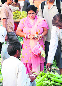 A woman carries vegetables in polythene bags in spite of ban on their use in Chandigarh.