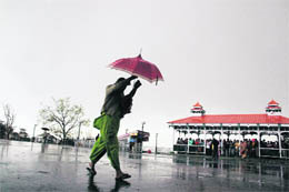A woman trying to shield herself from sudden rain at Shimla on Tuesday.