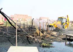 A JCB machine demolishes illegal sheds on the Tibba Road in Ludhiana on Tuesday. Photos: Inderjeet Verma