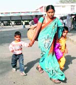 A woman along with her two kids walks out to look for alternative transport. Tribune photos: Ravi Kumar