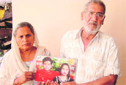 Gurdial Ram and his wife Asha Rani with the photograph of their son and daughter-in-law at their house in Gajjukhera village, Banur. 