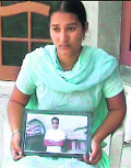 Baljit Kaur holding the picture of her brother, Daljit Singh. 
