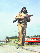 A policeman patrols the railway line in Jammu on Friday after militants blew up a track in Pulwama district on Thursday.