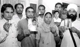 Relatives of Punjabis who have been sentenced to death in the UAE showing photographs of their kin in Jalandhar
