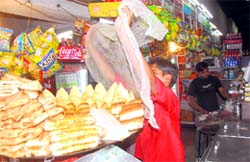 A shopkeeper tries to cover eatables at the Sector 17 Inter-State Bus Terminus in Chandigarh on Saturday. Tribune photo: Vinay Malik
