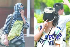 Girls cover their faces to save themselves from the heat at the India Gate in New Delhi