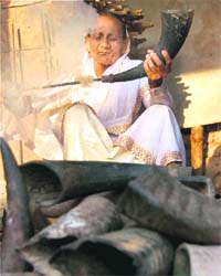 An elderly woman makes mohor singor pepa (a pipe made from buffalos horn) ahead of the Rongali Bihu celebrations in Assam
