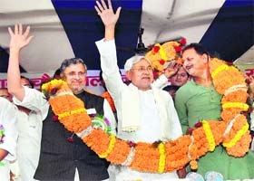 Bihar Chief Minister Nitish Kumar along with Deputy Chief Minister Sushil Kumar Modi being garlanded during the Baba Chauharmal birth anniversary function in Patna