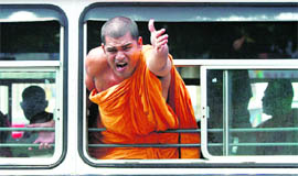 A monk, supporter of Sri Lankan armys former chief Gen Sarath Fonseka, yells out of a window of a bus after police arrested monks and broke a hunger strike in Colombo on Monday.