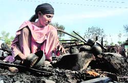 Hazra Begum sitting amidst the rubble of her burnt house in Doda Migrants Colony in Jammu on Tuesday. Tribune photo: Anand Sharma
