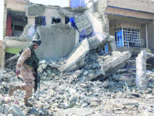 An Iraqi policeman inspects the scene of a bomb attack in Baghdad on Tuesday. 
