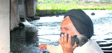 With covered nose, a Mauli Baidwan resident points to the sewage flowing out of a storm water pipe near Sector 67, Mohali