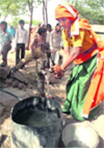A woman draws water from a hand pump at Barota village in Nuh district, which faces a problem of brackish water. 