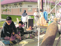 A woman holds her baby after moving to a hospital park for safety shortly after an earthquake hit Sinabang