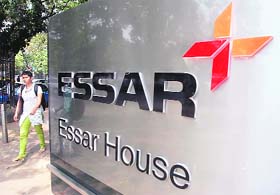 A woman walks past the Essar headquarters building in Mumbai