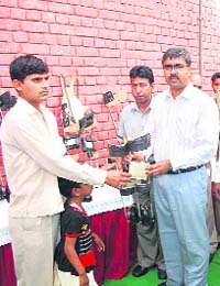 Deputy commissioner A. Sriniwas giving away calliper shoes to a disabled person in Rewari