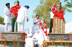 Relatives garland the statues of martrys after these were unveiled by Punjab Finance Minister Manpreet Badal at Johlaan village