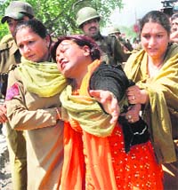 Police women arrest a striking government employee during a protest march in Srinagar on Saturday.