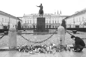 A man lights a candle in front of the Presidential Palace in Warsaw on Saturday.