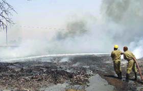 Firefighters dousing fire at the scrap market in Mundka, New Delhi
