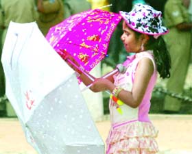 A girl protects herself from the sun near India Gate in New Delhi