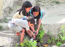 Children try to repair a damaged water pipeline in Dehradun