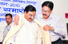 Chief Minister Ramesh Pokhriyal Nishank being honoured by Uttarakhand Principal Chief Conservator RBS Rawat in Dehradun on Sunday.