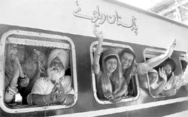 Pilgrims wave as a special train chugs out of Amritsar station on Sunday. 