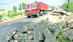 Eating into the road space, heaps of waste material pose a threat to commuters on the Rohtak-Jhajjar highway