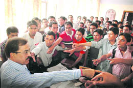 Activists of the SFI argue with CL Chauhan, Dean, Studies, Himachal Pradesh University, for their demands at Shimla on Monday. 
