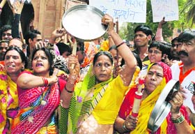 Women beat dishes during a demonstration against price rise in Bikaner
