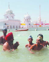 Devotees take a holi dip in the sarovar on the occasion of Baisakhi at Takht Sri Damdama Sahib in Talwandi Sabo