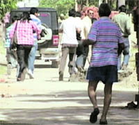 Mediapersons running away after Sunanda Pushkars father, Col PN Dass (retd), threw stones on them outside his house in Jammu on Tuesday. 