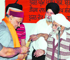 Chief Minister PK Dhumal being given a siropa (robe of honour) at the Sri Guru Singh Sabha Gurdwara by members of the managing committee of the shrine at Shimla on Wednesday.