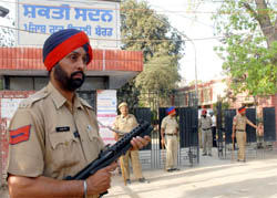 Policemen stand guard outside Shakti Sadan, main office of the PSEB, in Jalandhar on the first day of strike by board employees.