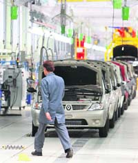 An employee walks past Logan cars on an assembly line at the Mahindra car manufacturing facility in Nashik.