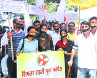 Youth Congress members wear black bands over their mouths in protest against lathi charge over party workers near the Vidhan Sabha last week at DCs office in Shimla on Friday.