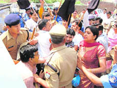 Congress workers show black flags to the state Health Minister for laying the foundation stone of a sub-health centre while policemen arrest protesters in Haridwar on Saturday.