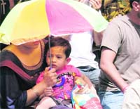 Too hot, too early: A woman protects the child from the heat in Ludhiana on Saturday