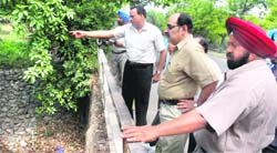 Officials of the Chandigarh administration and the municipal corporation visit the nullah crossing through Sector 23 in Chandigarh on Sunday. 