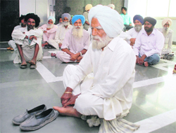 Landowners wait to get the cheques of land compensation amount at PUDA office in Sector 62, Mohali, on Monday.
