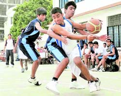 Two cagers of St Georges College, Mussoorie, try to wrest the ball from rival Doon School player in a match of the District Junior (U-18 years) Basketball Championship (Boys and Girls) in Dehradun on Monday.