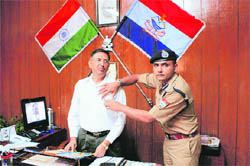 Abhinav Kumar, SSP, Dehradun, puts a flag of fire services on Uttarakhand Director General of Police Subhash Joshi in Dehradun on Monday. 